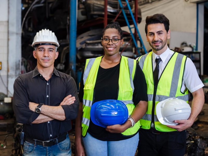 Happy full team engineering worker technician looking at camera, workshop manufacturing, Teamwork in industry factory. Warehouse auto parts